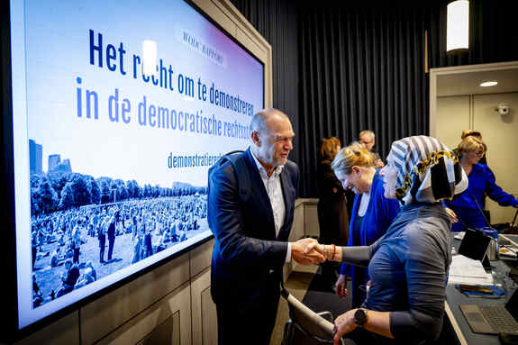 Kamerlid Karaaslan (D66), lid van de commissie voor Binnenlandse Zaken, schudt een onderzoeker de hand