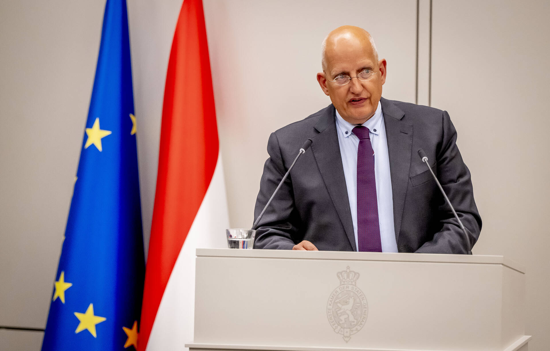 Een foto van een man die achter een spreekgestoelte staat